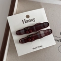 Detailed view of handmade red plaid hair clips with 3D cherry accents on a display card - Wave