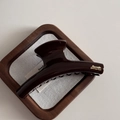 Detail of a chocolate brown shark hair clip with a golden Barrette La France text logo - Chocolate-Straight Bar