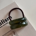 Detailed macro of dark red high-elastic hair tie with marble-textured resin rings - Double Curved / Green