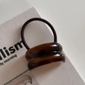 Detail of high-elastic hair tie with brown tortoiseshell resin bead and warm tones - Double Curved / Brown
