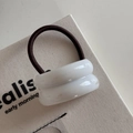 Detailed macro view of white resin hair rings with high-elastic dark brown bands on canvas - Double Curved / White