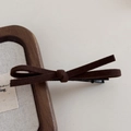 Détail d'une pince à cheveux nœud en daim marron foncé sur un cadre en bois d'hiver - Café Foncé