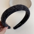 Detailed close-up of dark grey plush headband with handmade label and soft wool texture - Black Fluffy Fabric Headband