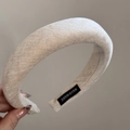 Close-up of cream-colored corduroy headband detail with a black handmade woven label - Headband / White