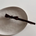 Détail d'une barrette nœud en acétate bordeaux avec lettrage doré Barrette la France - Marron