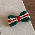 Close-up of handmade crochet Christmas bow hair clip with festive red and green yarn - Red and Green Bow