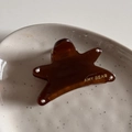 Dettaglio della pinza per capelli a forma di stella in acetato ambrato su vassoio - Marrone