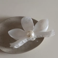 Dettaglio di un fermaglio per capelli a fiore bianco con perla centrale e petali in acetato - Fiore Bianco Texture Inchiostro