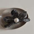 Dettaglio di una molletta per capelli a fiore con trama marmorizzata e perla centrale - Fiore Grigio Texture Inchiostro