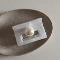 Dettaglio molletta per capelli in marmo bianco con perla lucida su un piatto ceramico - Rettangolare Bianco Texture Inchiostro