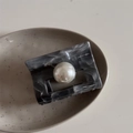 Detail of marble pattern hair claw clip with a large pearl on a ceramic tray - Ink Texture Gray Rectangular