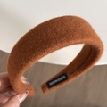Close-up of handmade orange plush wide headband showing fluffy wool texture and inner label - Brown