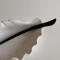 Detail eines schwarzen Acetat-Haarstabs mit silbernem France Handmade-Logo-Aufdruck - Dunkelbraun