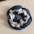 Detail von blauem Tweed-Haargummi mit weißer Spitzenbestickung und Vintage-Knopfdesign - Blau Tweed Spitze Stil