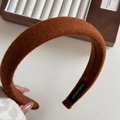 Close-up of handmade brown velvet plush headband with thick sponge padding and label - Orange