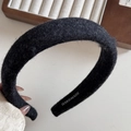 Macro detail of black handmade wool blend sponge headband showing texture and branding - Black
