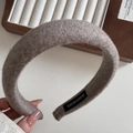 Close-up of a thick grey-brown wool blend headband featuring a handmade label and soft texture - Oatmeal