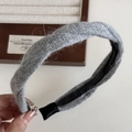 Dettaglio della fascia in maglia grigia con design a incrocio e morbida trama in peluche - Grigio