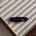 Detailed macro view of deep purple velvet hair tie with a silver metal Love charm - Charming Purple Velvet Duckbill Clip