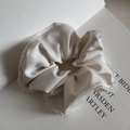 Dettaglio dell'elastico in raso crema con bordo in pizzo elegante e trama di tessuto lucido - Bianco Sporco