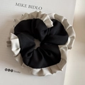 Détail d'un chouchou vintage français en tissu noir avec des bords froissés crème - Chouchou à Bord Volanté Patchwork Noir et Blanc
