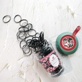 Detailed view of 130 pieces of black elastic rubber bands in floral herbal tea bottle - Green