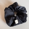 Detail of black handmade scrunchie showing fabric texture and 'Hand Made' woven label - Scrunchie / Black