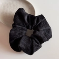 Detail eines großen schwarzen Cord-Haargummis mit feiner Rippstruktur und weichem Stoff - Vintage Samt - Schwarz