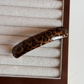 Nahaufnahme einer Haarspange mit Leopardenmuster aus poliertem Acetat auf Schmucktablett - Dunkles Leopardenmuster - Federclip