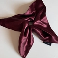 Close-up of wine red satin scrunchie showing glossy texture and 100% polyester label - Square Scrunchie / Burgundy