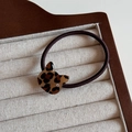 Detail of leopard print cat charm hair tie with crystal accent on a jewelry tray - Light Cat / Hair Tie