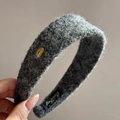 Dettaglio del cerchietto grigio in peluche con targhetta dorata e morbida maglia - Grigio