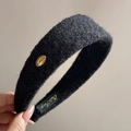 Détail d'un serre-tête en peluche noire avec texture tricotée et plaque dorée Korea - Noir