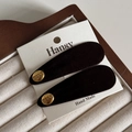 Gros plan de barrettes en velours noir avec boucles dorées sur un coffret à bijoux - Boucle Dorée Velours Brun Foncé / Brun Foncé
