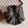 Macro-opname van donker taupe visgraat wollen scrunchie met gedetailleerde textuur - Donkergroen