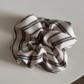 Close-up of elegant striped satin scrunchie with soft pleated texture and cream black pattern - Classic Scrunchie / Cream Striped Scrunchie