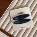 Detailed view of two denim texture hair clips with silver letter labels on display card - Silver Label Denim - Long Oval