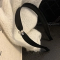 Close-up of a black satin headband featuring a sparkling silver rhinestone bow detail - Black