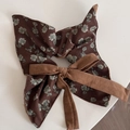 Detalle de coletero floral marrón que muestra la textura suave de la tela y el estampado - Marrón