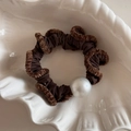 Detail of coffee brown scrunchie with faux fur trim and white pearl on a ceramic tray - Dark Coffee
