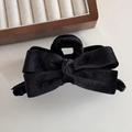 Dettaglio dell'elegante fermaglio per capelli in velluto nero con fiocco e trama morbida - Nero