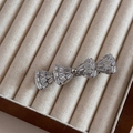 Detalle de una pinza de pelo con lazo de diamantes de imitación y circonitas baguette - Estilo de Lazo de Doble Capa Plateado