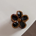 Vista dettagliata della molletta a fiore in resina tartarugata con petali neri lucidi - Floreale Nero Con Bordo Tartarugato (Piccolo)