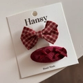 Détail de pinces à cheveux de fête rouges avec nœud écossais et design ovale floqué - Nœud Plaid