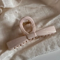 Detailed top view of large marble texture shark clip on natural linen fabric background - Bowknot Style / Wavy Toffee