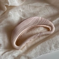 Macro shot of large ripple textured bow hair claw clip on soft beige fabric background - Crescent Moon / Wavy Toffee