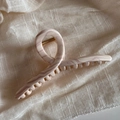 Macro shot of large pink and white acetate hair claw with durable gold metal spring - Hanger Style / Wavy Toffee