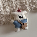 Detailed close-up of a cute knitted white bear doll with a blue sweater and guitar bag accessory - Funny White Puppy - Standing Duckbill Clip