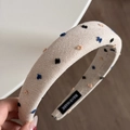 Detail eines Haarreifs in Beige mit bunten Punkten und handgefertigtem Etikett - Beige Stirnband mit 3D-Punkten