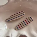 Dettaglio del fermaglio per capelli a righe arcobaleno in un vassoio decorativo - Bianco Crema